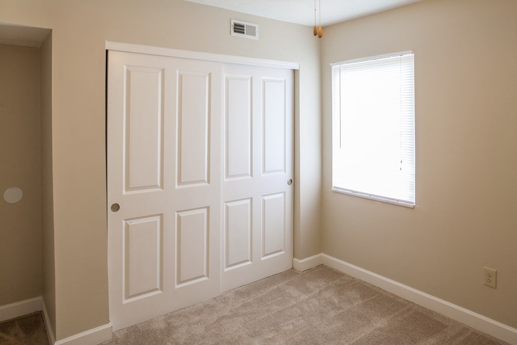 an empty room with two doors and a window