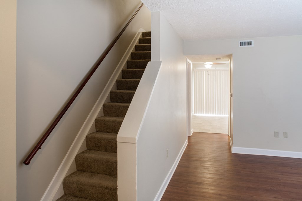 the view of the stairs from the basement of a house with white walls and wood