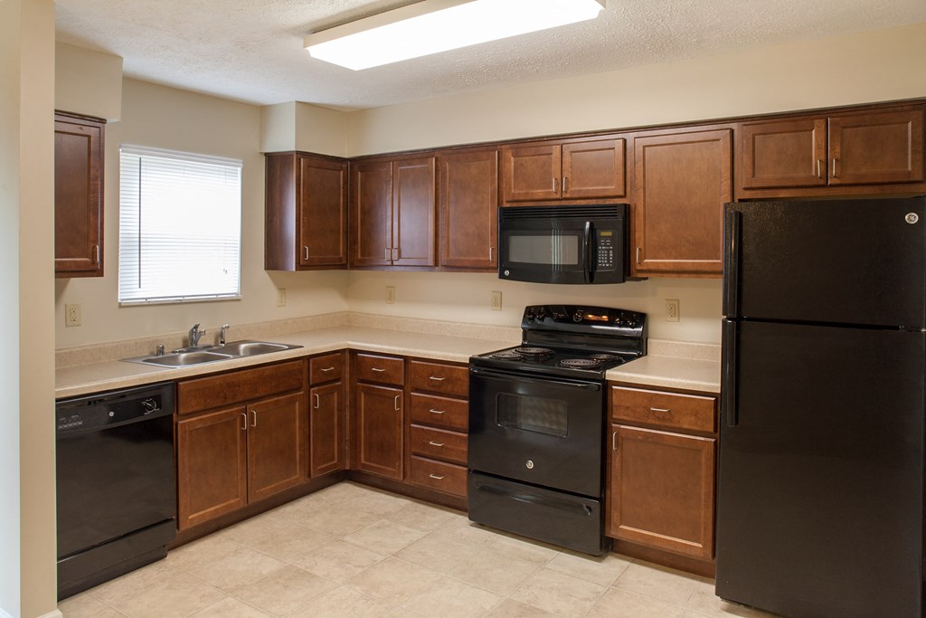 a kitchen with black appliances and wooden cabinets