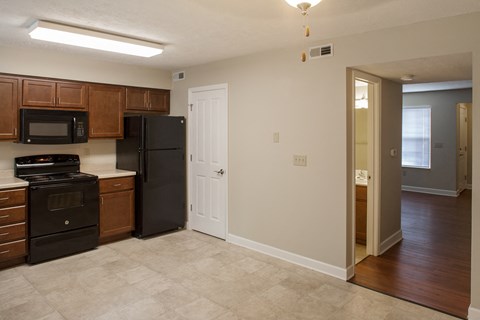 an empty kitchen with black appliances and wooden cabinets