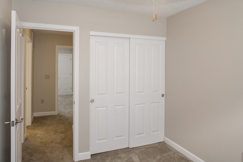 a bedroom with two closets and a door to a hallway