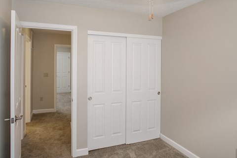 a bedroom with two closets and a door to a hallway