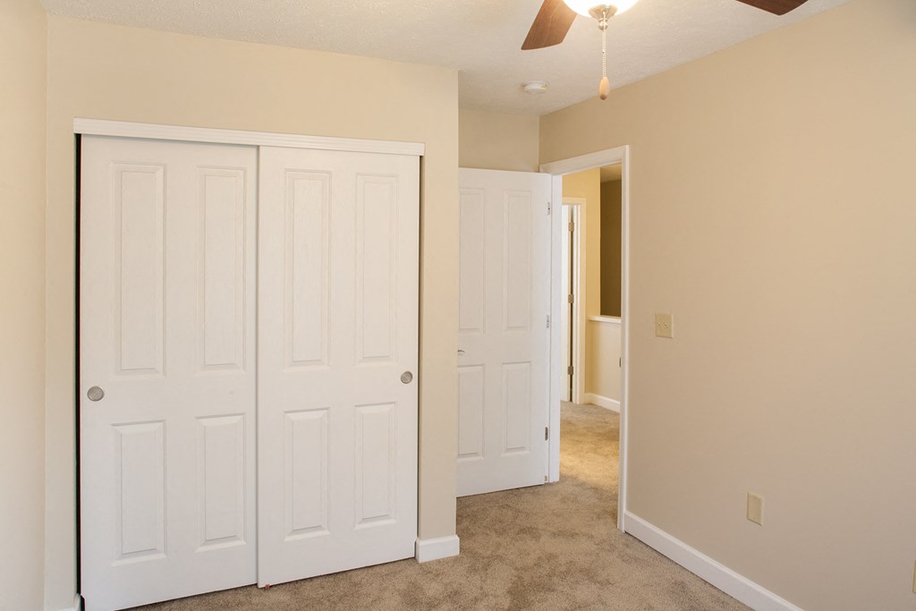 a bedroom with two closets and a door to a hallway