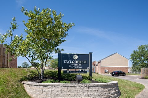 a stone retaining wall surrounds a sign apartments