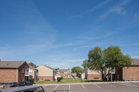an empty parking lot in front of an apartment complex