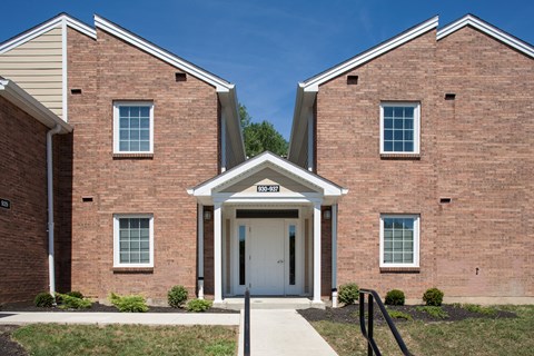 a brick building with a white door and a porch