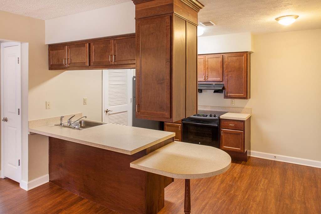 a kitchen with wooden cabinets and a sink and a counter
