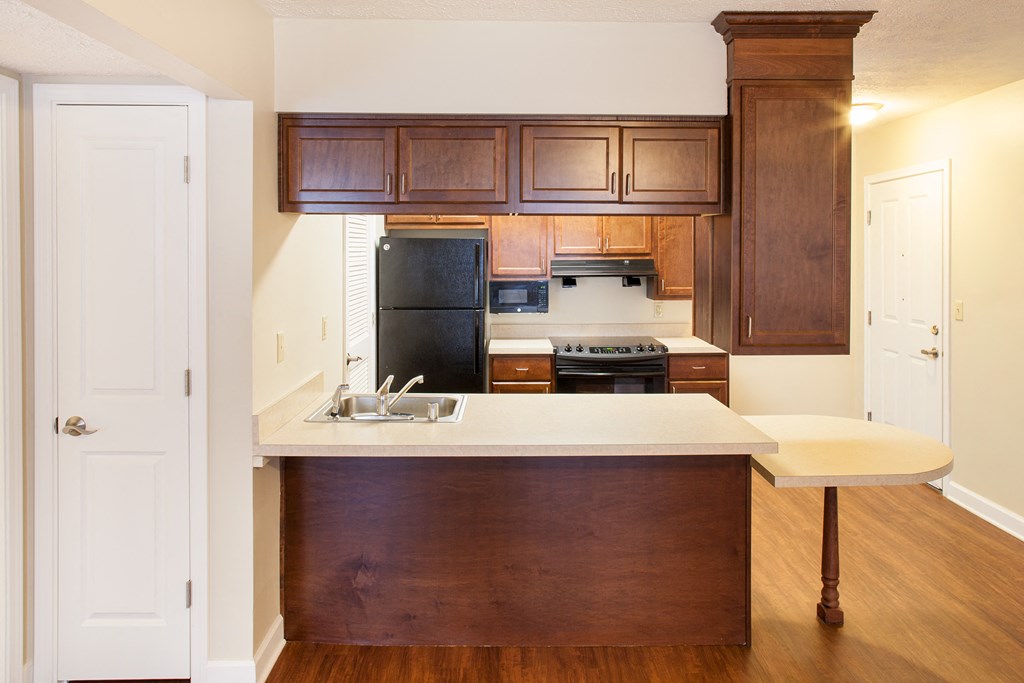 a kitchen with wooden cabinets and a white counter top
