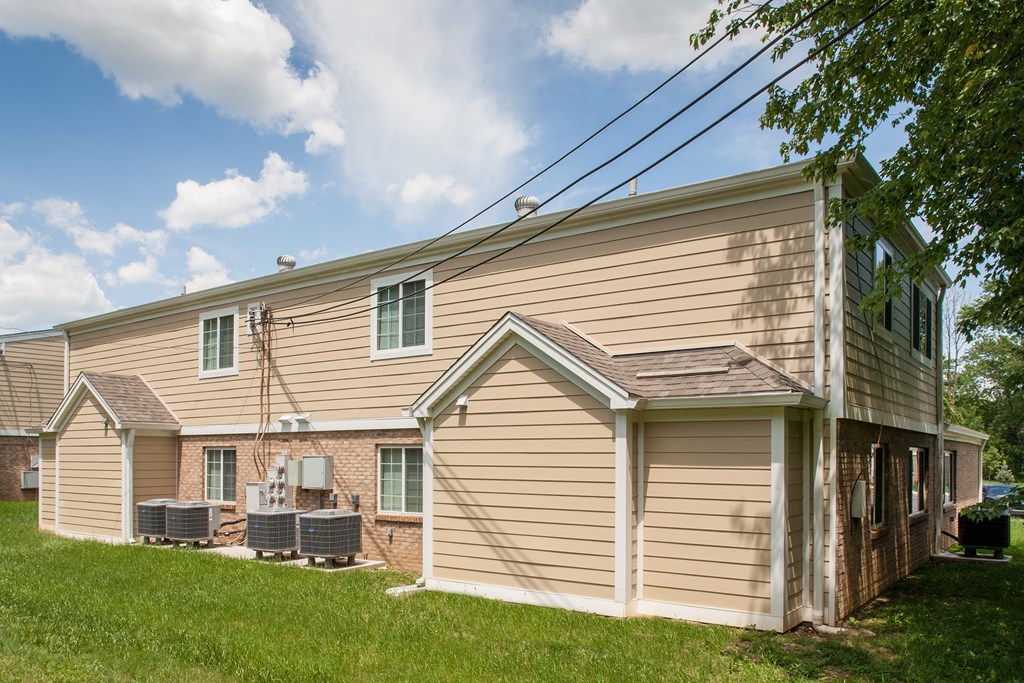 the side of a house with a garage and a grassy yard