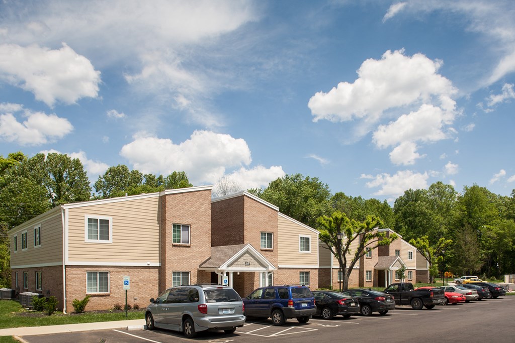 a parking lot with cars in front of an apartment building