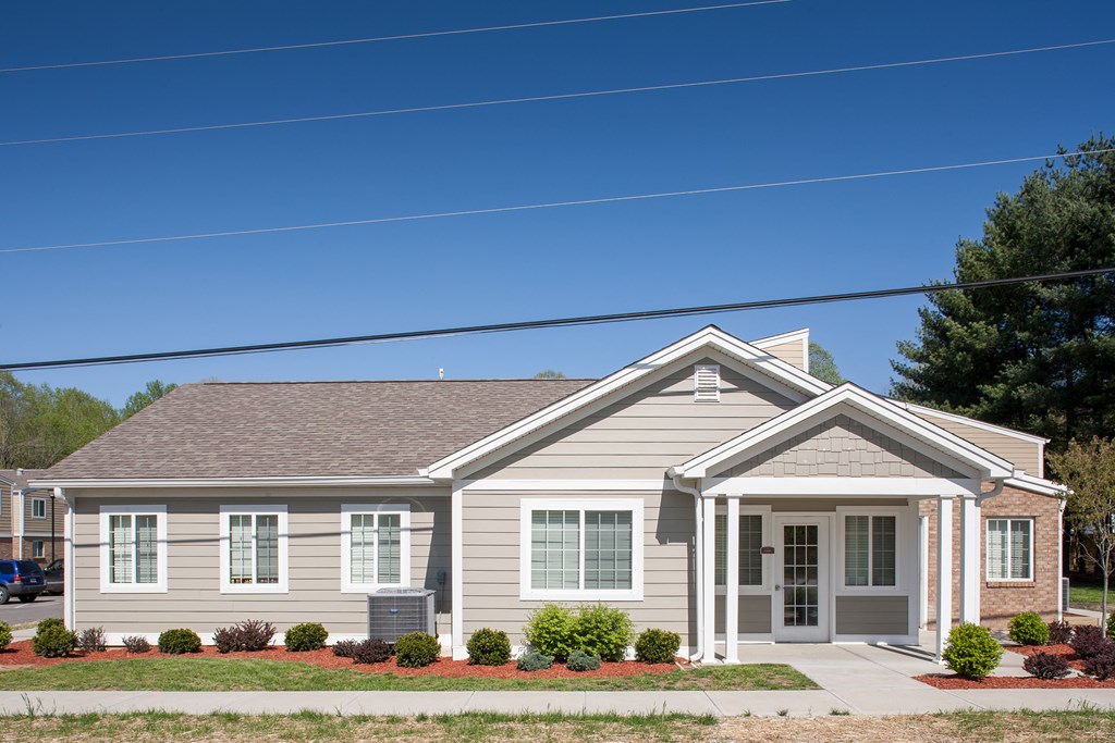 a white house with a gray roof and a sidewalk