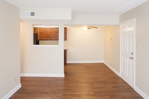 an empty living room with wood flooring and white walls