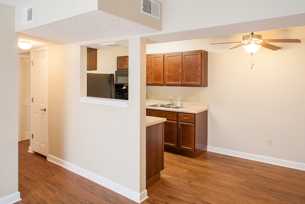 the view of a kitchen and a living room with a ceiling fan