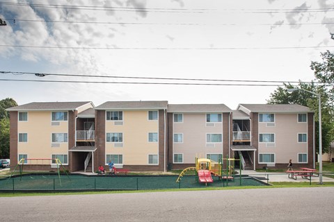an image of an apartment building with a playground