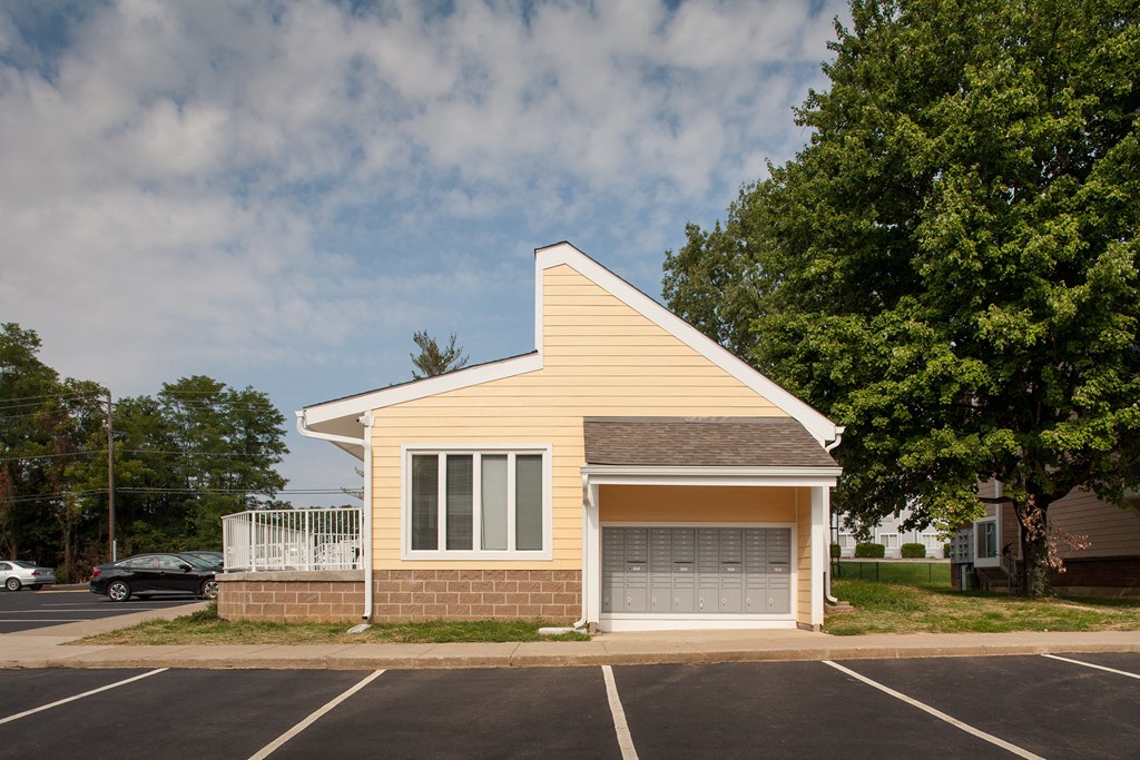 a small yellow house with a garage door in a parking lot