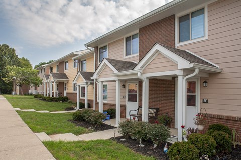 a row of houses with a sidewalk and grass