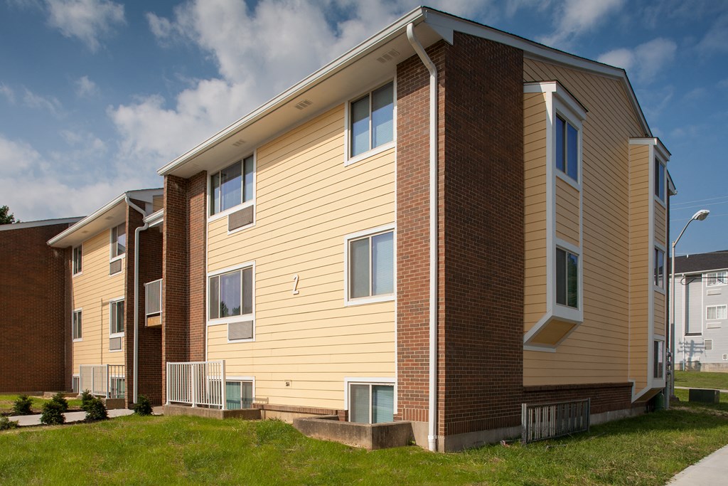 a row of houses with yellow and brown siding and brick