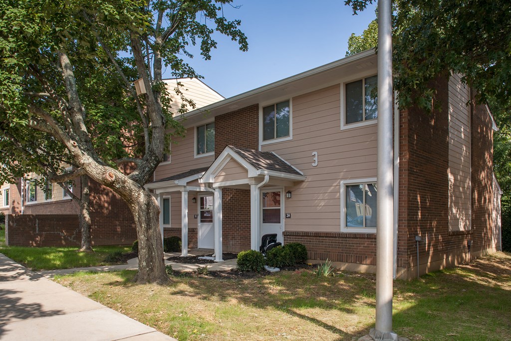 the exterior of a house with a tree in front of it