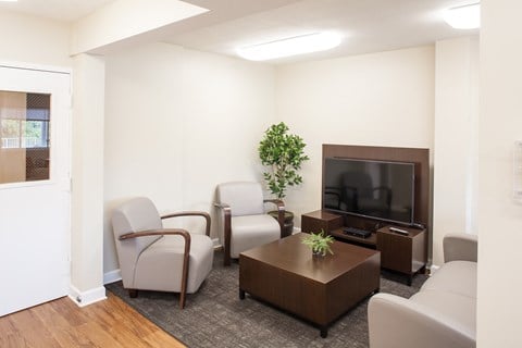 a living room with white furniture and a television