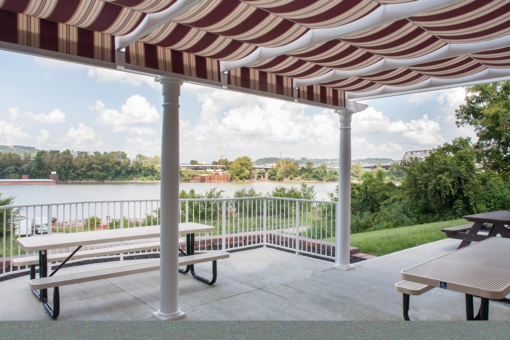 a red and white striped awning over a patio with benches
