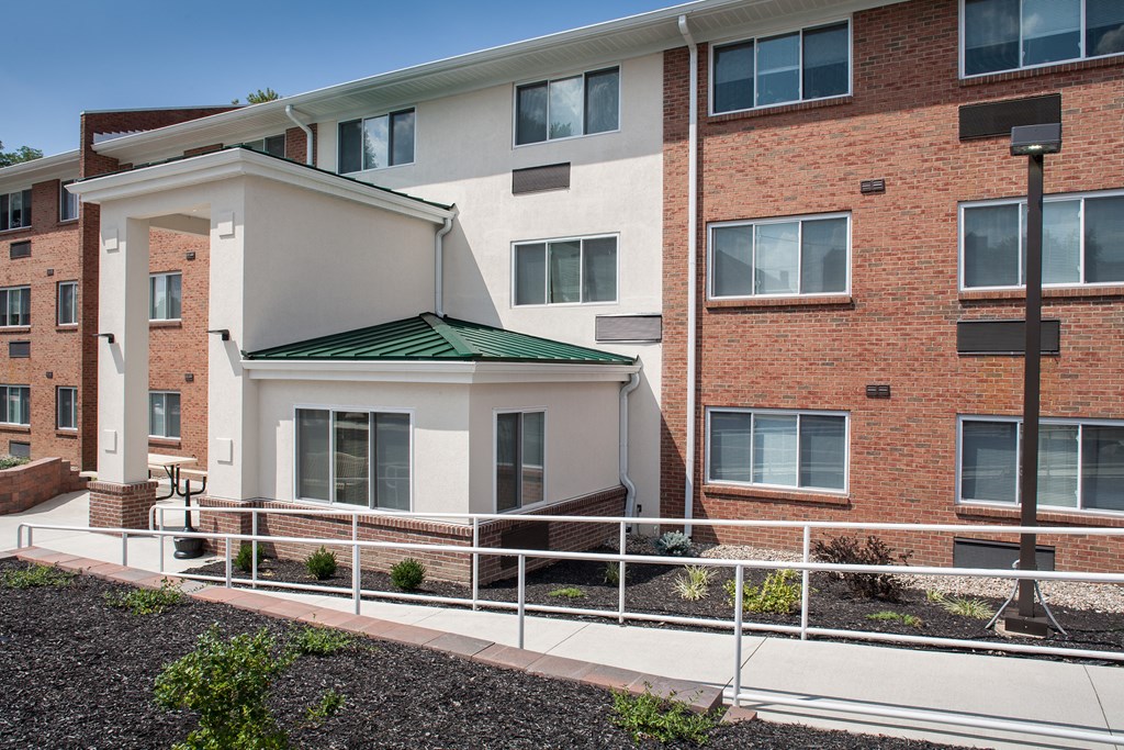 a brick building with a green roof and a balcony
