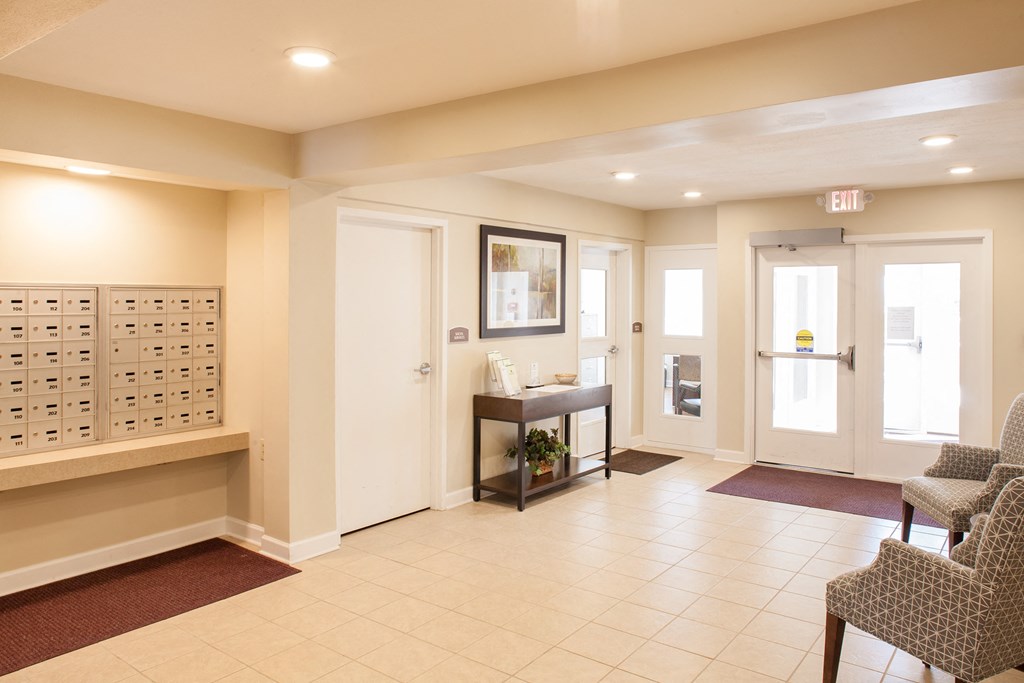 a lobby with two chairs and a table and two doors