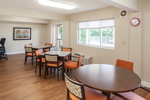 a dining room with tables and chairs and a clock on the wall