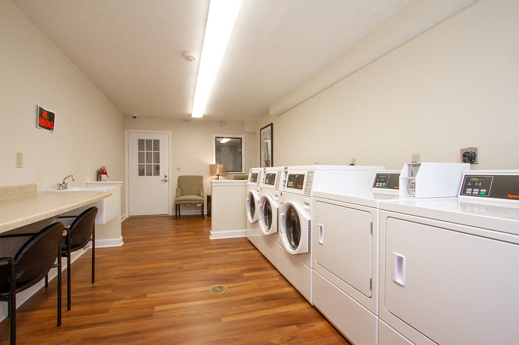 a laundry room with washers and dryers and a table with chairs