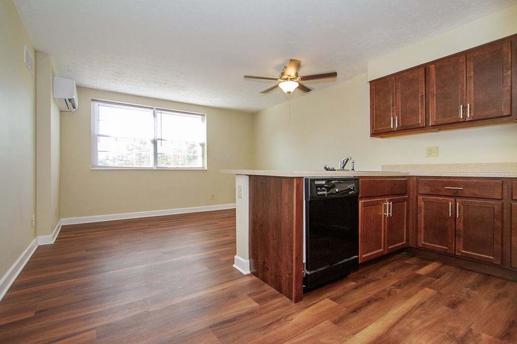 an empty kitchen with wood flooring and a ceiling fan