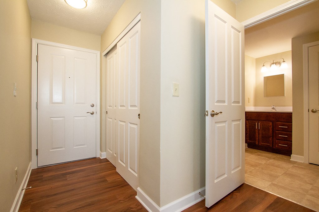 an empty hallway with white doors and a bathroom