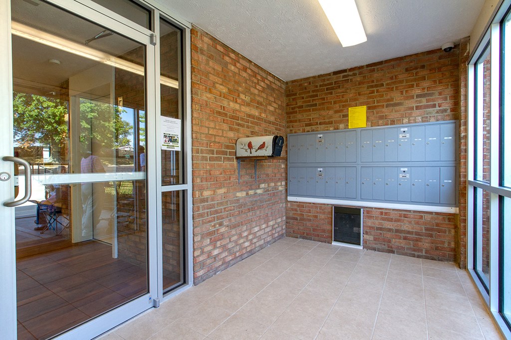 the entrance to a building with a brick wall and glass doors