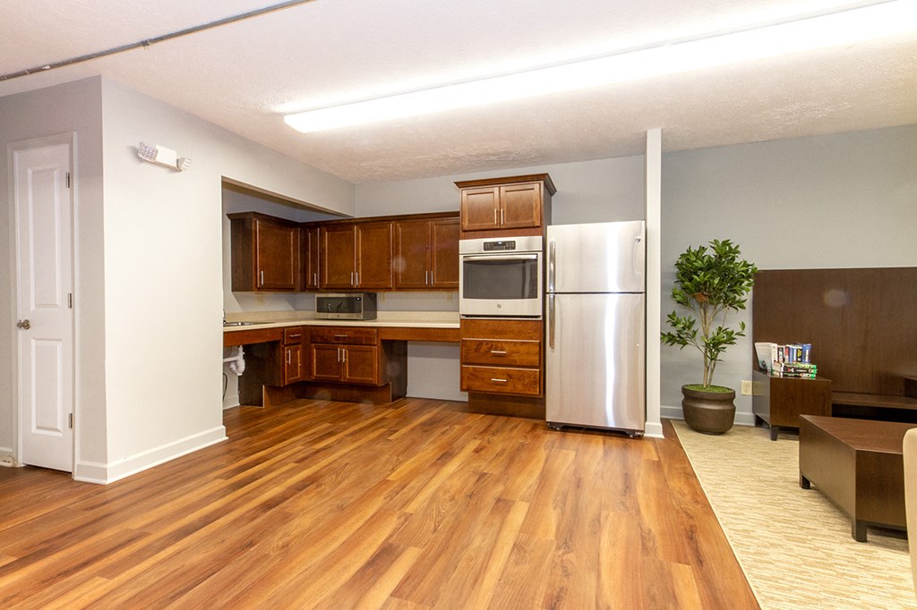 an empty kitchen with wooden floors and a refrigerator