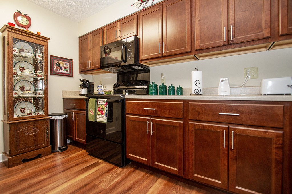 a kitchen with wooden cabinets and a stove and a microwave