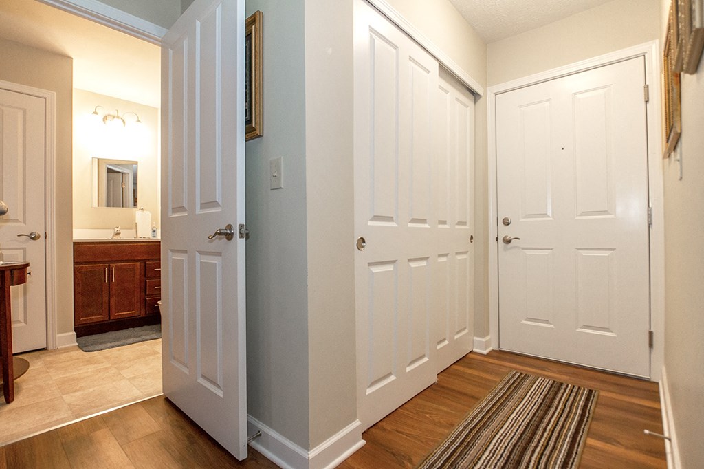 a hallway with white doors and a bathroom with a sink
