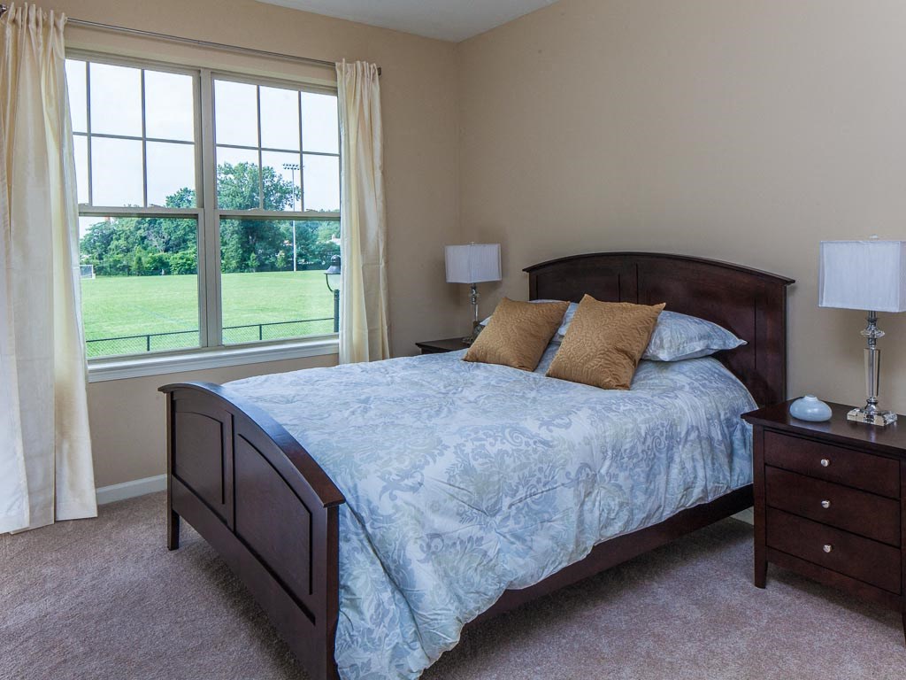 a bedroom with a bed and a large window