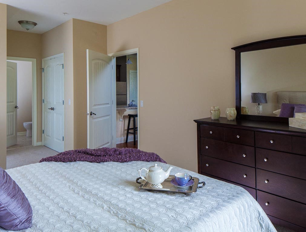a bedroom with a bed and a tray with a coffee cup on it