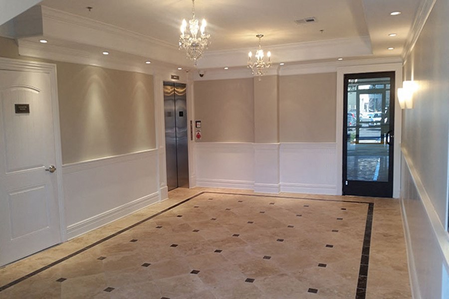 a ballroom with a rug and chandeliers