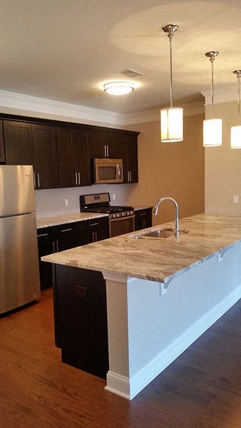a kitchen with an island and a stainless steel refrigerator