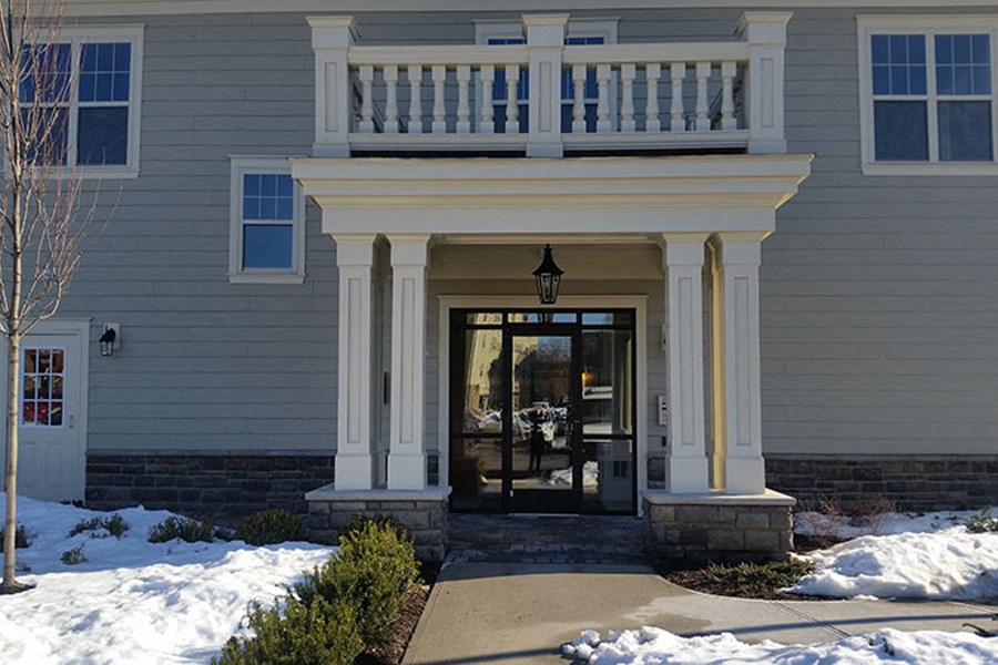 a house with a porch and a walkway in the snow