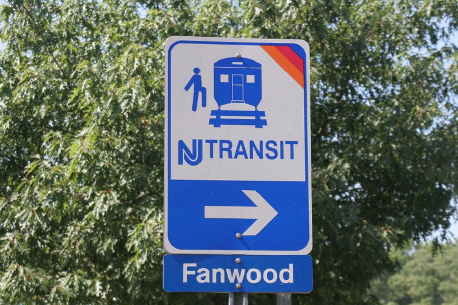 a blue and white train sign with an arrow pointing to a trolley