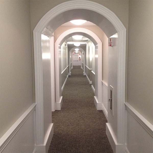 a long hallway with a carpeted floor and an arched door way