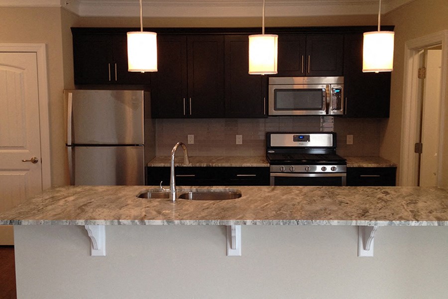 a kitchen with granite counter tops and black cabinets