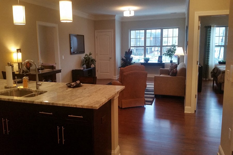 an open kitchen and living room with a couch and a tv