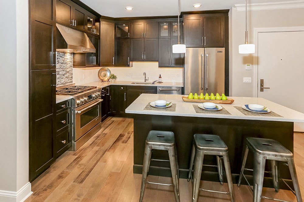 a large kitchen with a center island with three stools