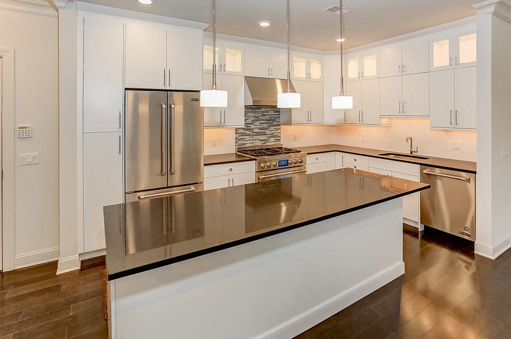 a kitchen with white cabinets and stainless steel appliances