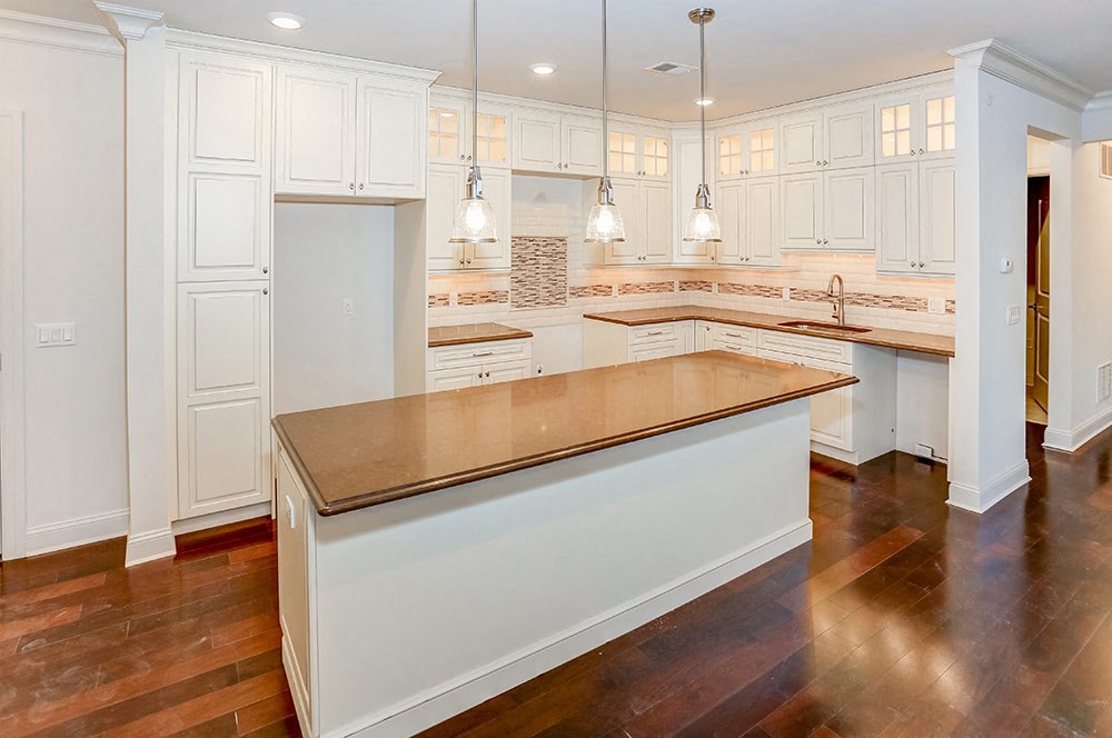 a large kitchen with white cabinets and a counter top