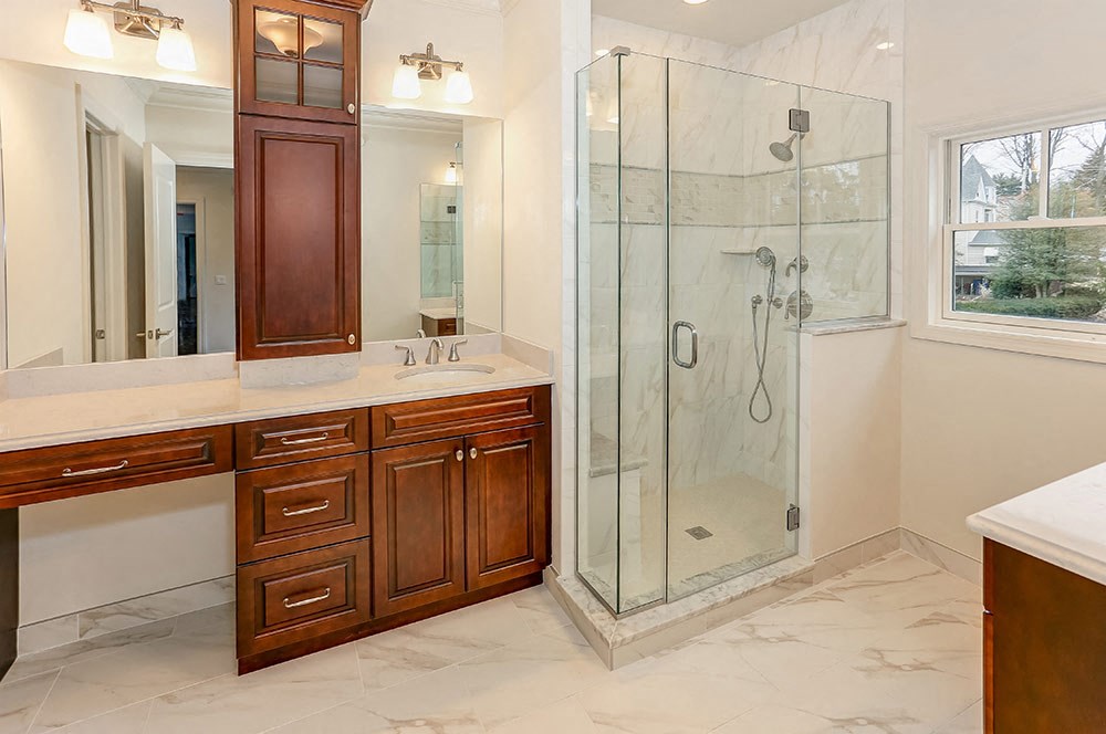 a bathroom with a shower and wooden cabinets
