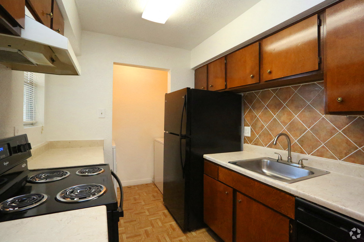 a kitchen with a stove and a refrigerator and a sink