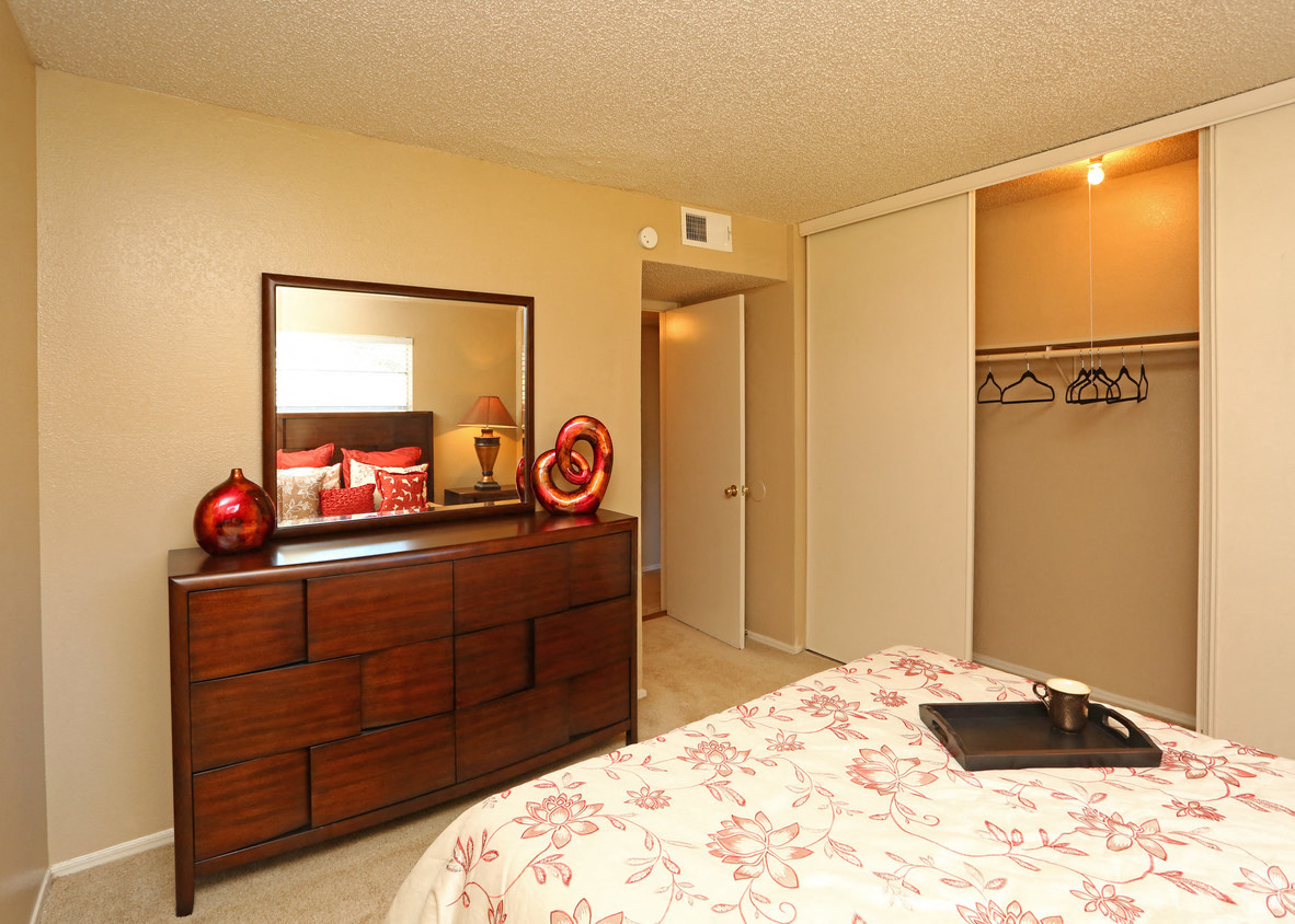 a bedroom with a large bed and a mirror