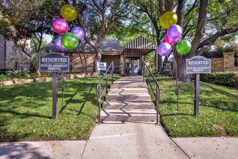 the entrance to the reserved parking lot with stairs and balloons